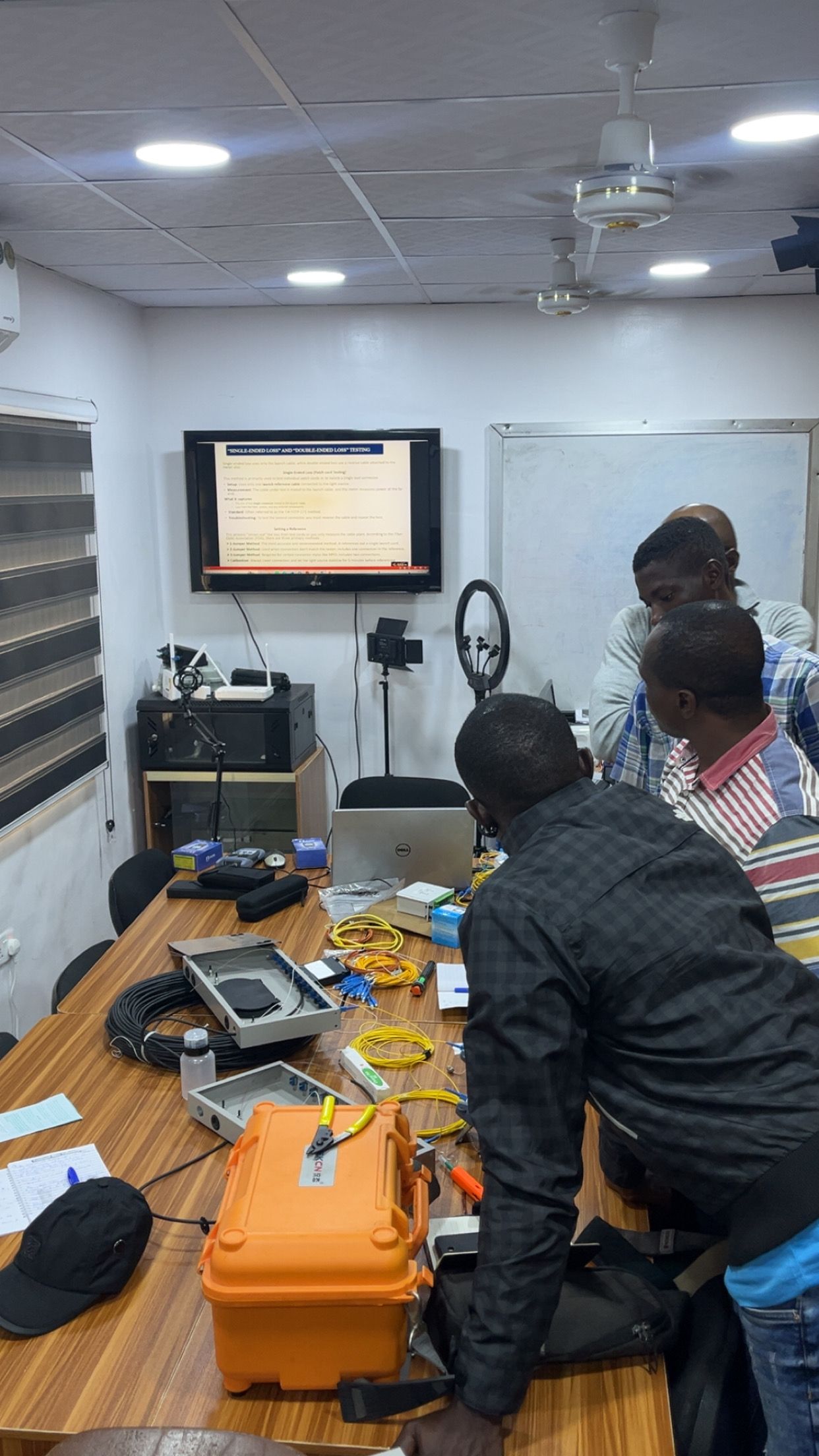 People working with equipment on a bench in a training room
